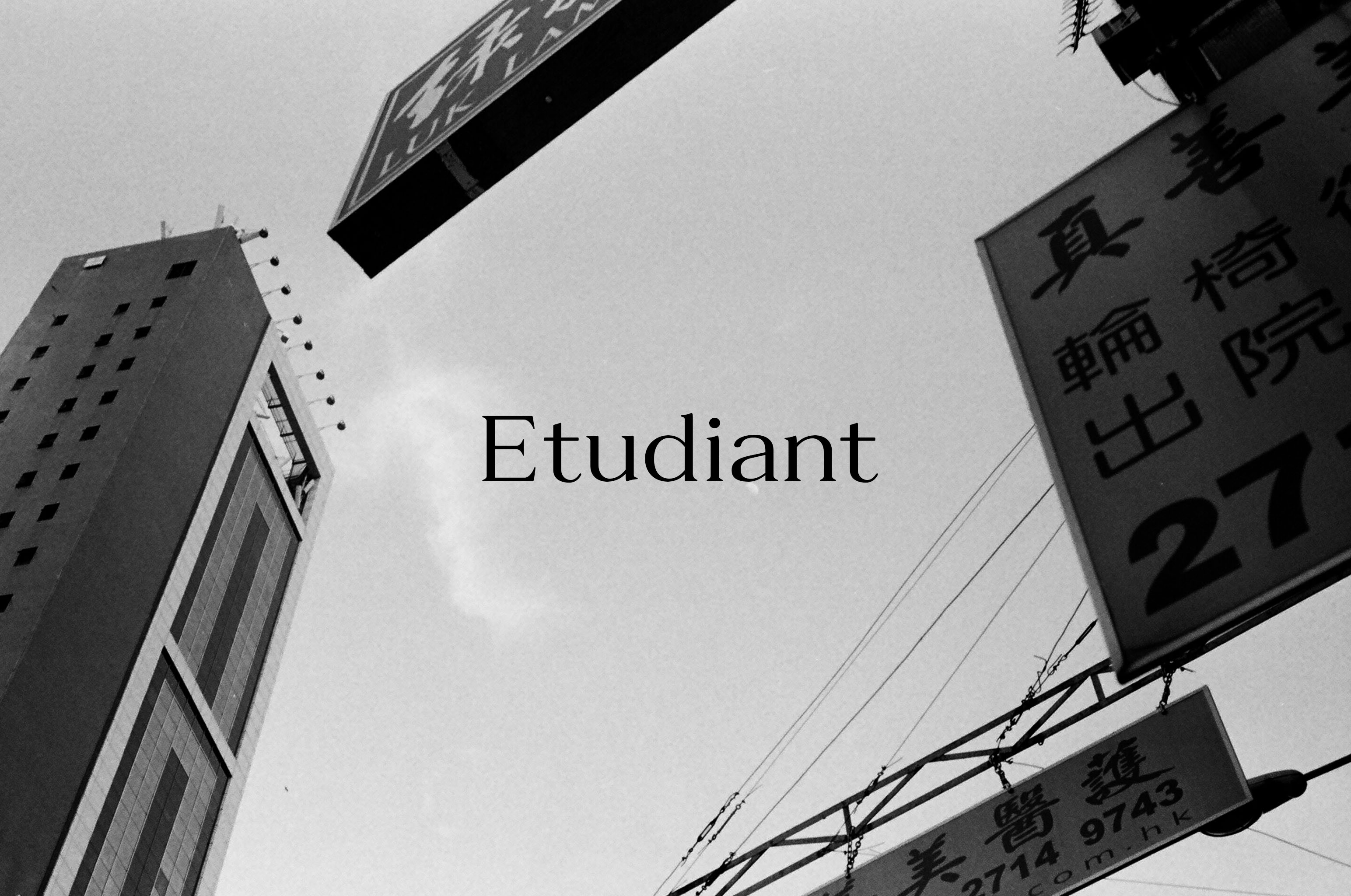 B/W image of sky with building and hanging signs in frame. Text in center, reads: Etudiant