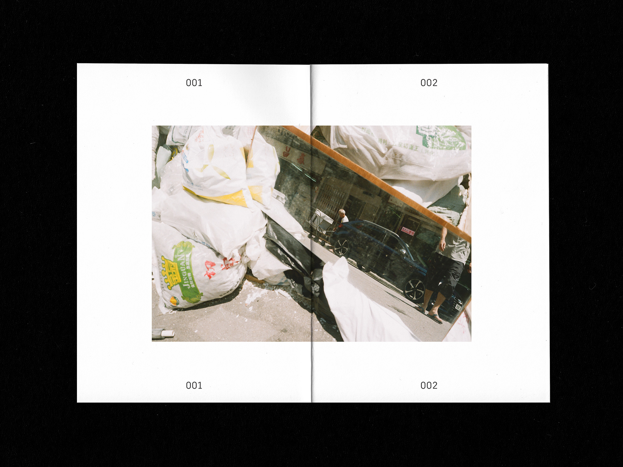 Spreads of zine: mirror laying against piled up bags of construction debris on the street
