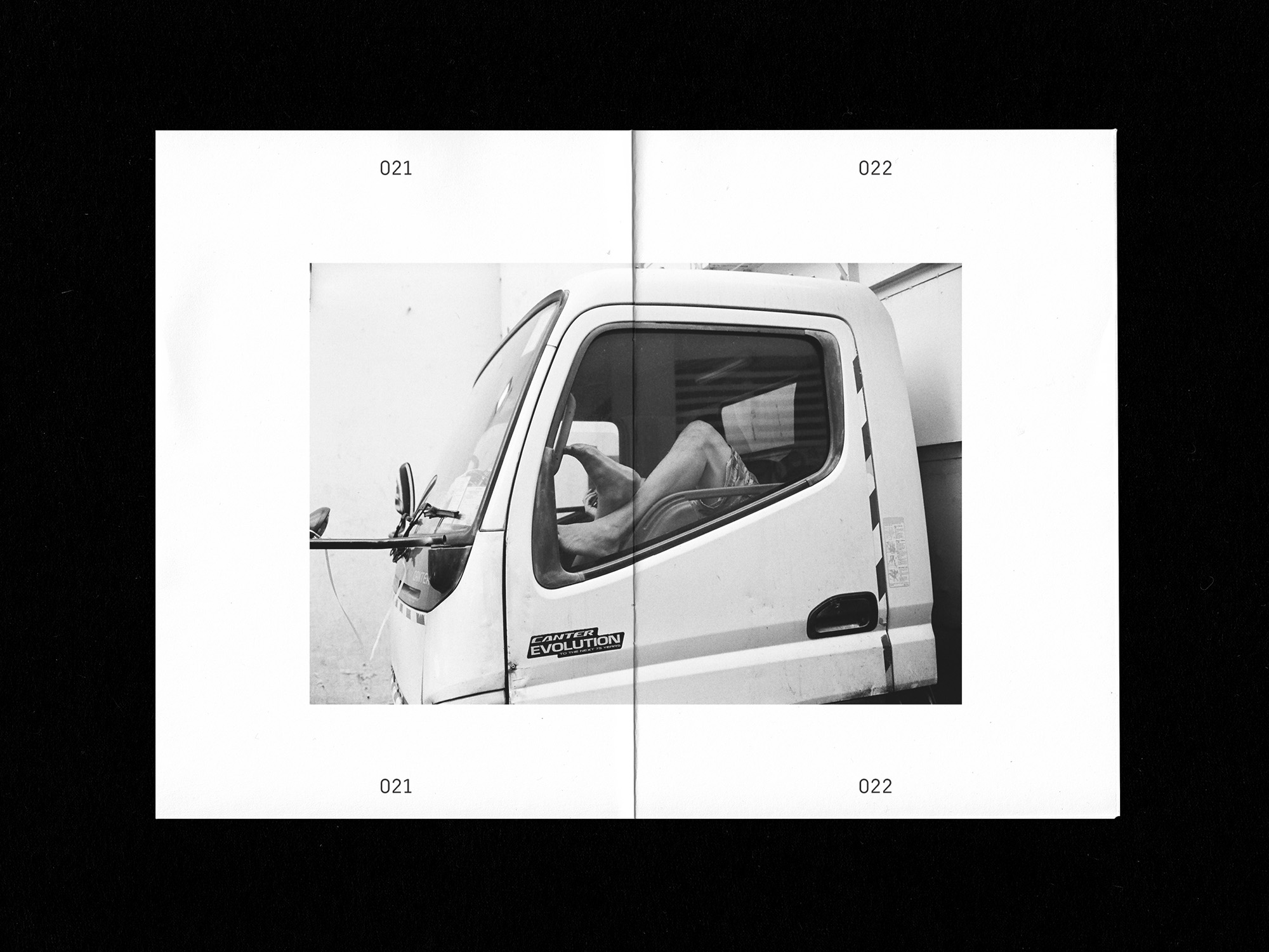Spreads of zine: man laying down in truck with feet against window in b/w